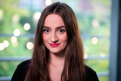 Women smiling in red lipstick and black top