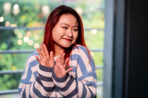 Women smiling and looking to the right hand side in white and blue horizontally striped sweater